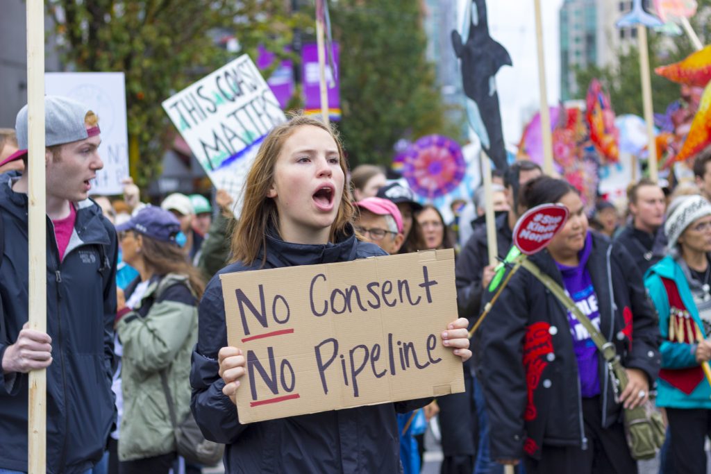Protester_holding_sign_stating_No_Pipeline_No_Consent_during_a_Kinder_Morgan_Pipeline_Rally_on_September_9th_2017_in_Vancouver_Canada-1024×683