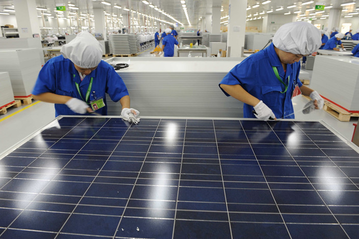 Workers labor in a factory of a Chinese solar panel maker in Hangzhou